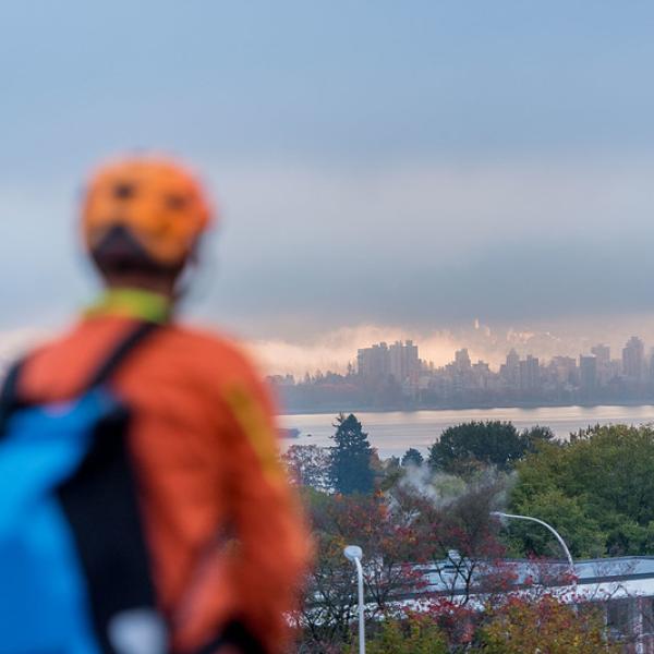 Photo of person where bike helmet looking with a view of the city