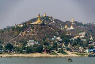 Myanmar temple on top of a hill with pointed gold roofs